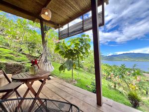 a porch with a swing and a table and chairs at Tierra Alta, Refugio de Montaña, Sauce in Sauce