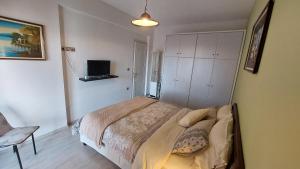 a bedroom with a bed and a tv on a wall at Lux Center Apartment in Litochoro