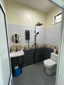 ein Badezimmer mit Toilette, Waschbecken und Spiegel in der Unterkunft Homestay Aishah in Kota Bharu