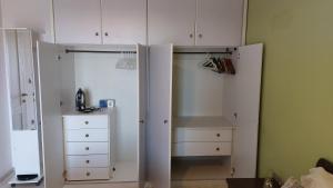 a closet with white cabinets and a dresser at Lux Center Apartment in Litochoro +14 photos