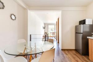 a dining room with a glass table and chairs at Moderno Loft Totalmente Equipado in Lomas de Angelopolis