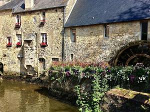 バイユーにあるApartment in Bayeux near D-Day Beachesの花の川の横の古い石造りの建物 +22枚の写真