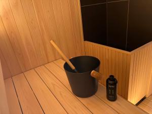 a black bucket with a wooden spoon in a sauna at Ryokan iriya in Tokyo