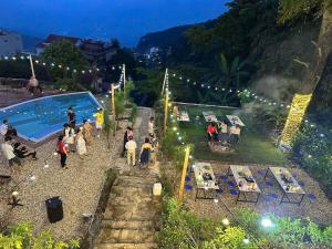 a group of people standing near a swimming pool at night at Tram Homestay - Venuestay in Tam Ðảo