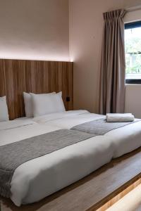 a bedroom with two beds and a window at Laman Villa Langkawi in Pantai Cenang