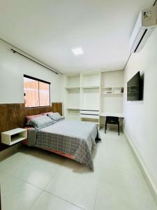 a bedroom with a bed and a television in it at Lindo flat próximo do centro in Formosa