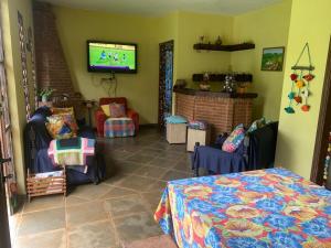 a room with a bed and a tv on a wall at Chácara do Maurão - tranquility and nature in Serra Negra +34 photos