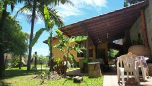 a house with two white chairs in front of it at Chácara do Maurão - tranquility and nature in Serra Negra