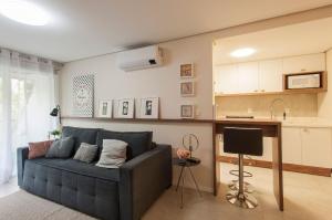 a living room with a blue couch and a kitchen at Locar - in Canela Villaggio Caracol Novissimo in Canela