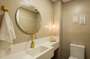 a bathroom with a sink and a mirror and a toilet at Locar - in Canela Villaggio Caracol Novissimo in Canela +22 photos