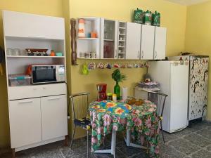 a kitchen with a table and a refrigerator at Chácara do Maurão - tranquility and nature in Serra Negra