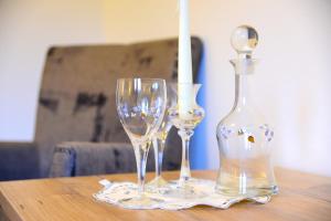 three wine glasses and a bottle on a table at Appartement Albert und Helene Koller in Söll +20 photos