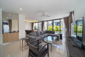 a living room with a couch and a table at 5bdr pool villa in Laguna Park 2 in Phuket