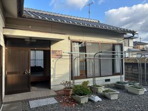 星乃冈木の家ゲストハウス松山本館的前面有盆栽的房屋