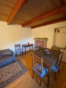 a living room with a table and chairs and a fireplace at La casa gialla, Rosazza, Biella in Rossaza