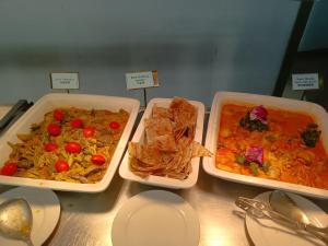 three trays of food sitting on top of a table at Novotel Atlantis Shanghai - Enjoy our great-valued breakfast in our rooftop revolving restaurant with a stunning river view & utilize our FREE self-serviced laundry in Shanghai