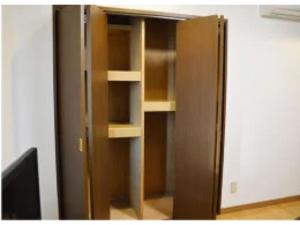 a wooden closet with empty shelves and a television at Monzen House Private room - Vacation STAY 49377v in Kasama