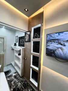 a living room with a television on a wall at استوديو فندقي بالزمالك in Cairo