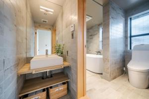 a bathroom with a sink and a toilet and a tub at Yotsuki Machiya House in Nishinotōindōri +44 photos