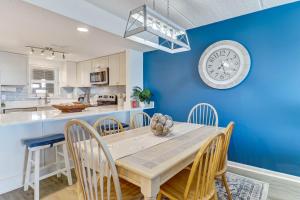 a dining room with a table and a clock on a blue wall at C5 Amelia South condo in Fernandina Beach +23 photos