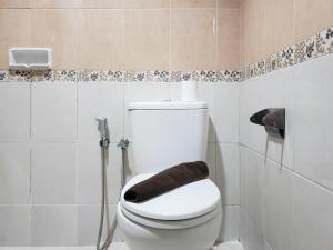 a bathroom with a white toilet and a shower at Minimalist and Comfy 1BR at The Boulevard Apartment By Travelio in Jakarta