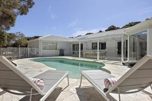 a house with a swimming pool and two chairs at Harlech House Rye in Rye