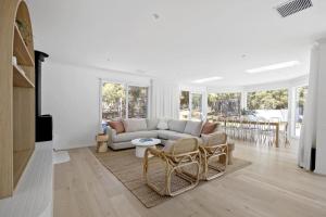 a white living room with a couch and chairs at Harlech House Rye in Rye