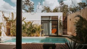 a swimming pool in front of a house at Casa del Loro 3 BR Luxury Villa with Private Pool in Tulum
