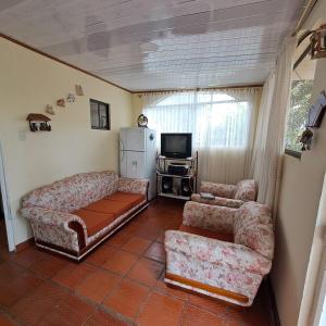 a living room with two couches and a television at Hermosa casa de campo en Boyacá in Ramiriquí