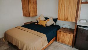 a small bedroom with a bed with a teddy bear on it at Casa del Loro 3 BR Luxury Villa with Private Pool in Tulum +14 photos