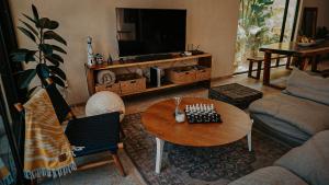 a living room with a table and a tv at Casa del Loro 3 BR Luxury Villa with Private Pool in Tulum