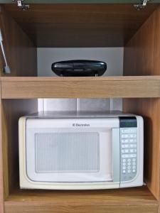 a microwave oven sitting inside of a cabinet at Apto no Centro de São Leopoldo in São Leopoldo
