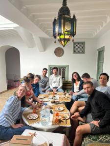 a group of people sitting around a table eating at Dar la famille Marrakech in Marrakech +24 photos
