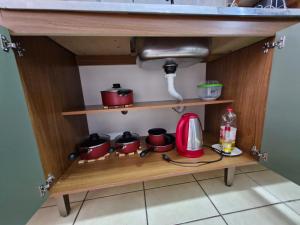 a kitchen cabinet with pots and pans and a sink at Apto no Centro de São Leopoldo in São Leopoldo