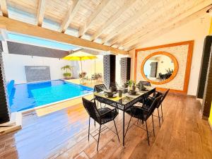 una sala da pranzo con tavolo, sedie e piscina di Casa Rinconcito Del Sol Alberca Climatizada a Tonatico