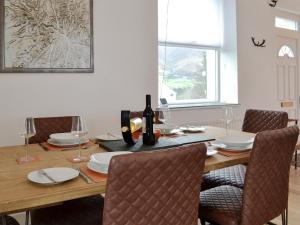 a dining room table with wine bottles and chairs at Katellen Cottage in Threlkeld