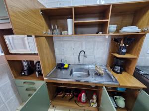 a small kitchen with a sink and a microwave at Apto no Centro de São Leopoldo in São Leopoldo