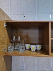 a wooden shelf with glasses and wine glasses at Apto no Centro de São Leopoldo in São Leopoldo