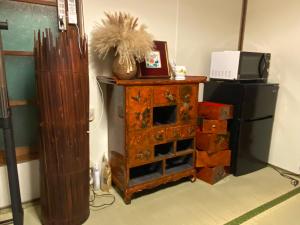 a room with a wooden dresser and a microwave at 仁源和 in Tokyo +6 photos