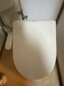 a white toilet in a room with a remote control at 仁源和 in Tokyo