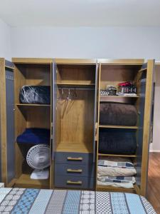 a closet with wooden shelves and blue cabinets at Apto no Centro de São Leopoldo in São Leopoldo