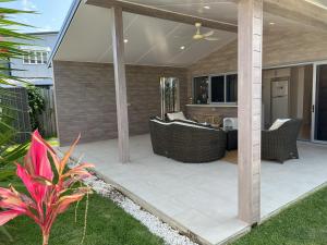 a patio with a couch and chairs on it at Beachside retreat in Caloundra