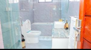 a bathroom with a toilet and a sink and a shower at Waterpark view apartment 1A in Mombasa +15 photos