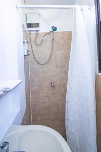 a bathroom with a shower with a toilet and a sink at Casa de Helen in Antiguo Cuscatlán +13 photos