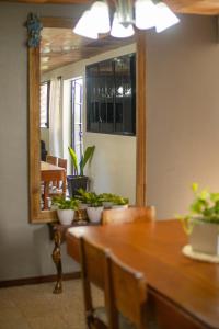 Un comedor con una mesa y un espejo. en Casa de Helen, en Antiguo Cuscatlán