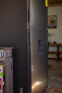 a stainless steel refrigerator in a kitchen at Casa de Helen in Antiguo Cuscatlán