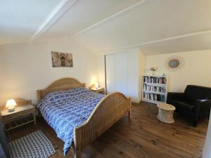 a bedroom with a bed and a black chair at Gîte Authentique avec Piscine, Cheminée et Étang Privé à Naussannes - Proche Bergerac - FR-1-616-205 in Naussannes