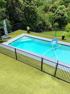 a swimming pool with a fence around it at The Country House at Hunchy Montville in Flaxton