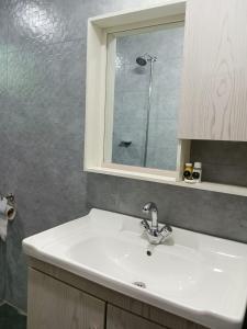 a bathroom with a sink and a glass shower at Osama's Room for Rent in Murree