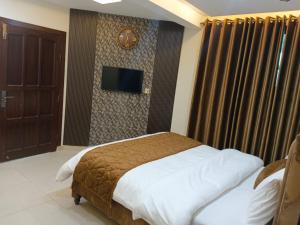 a bedroom with a bed and a tv on a wall at Osama's Room for Rent in Murree